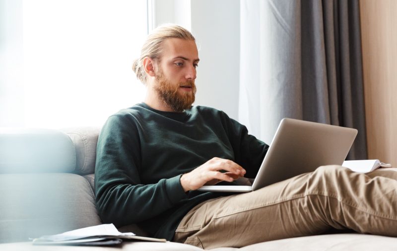 Man sitting on couch using a laptop